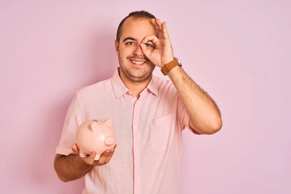 Jovem Segurando Piggybank Sobre Fundo Rosa Isolado Com Rosto Feliz — Fotografia de Stock