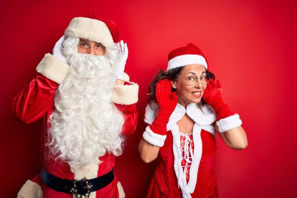 Paar Mittleren Alters Das Weihnachtsmannkostüm Und Brille Über Isoliertem Rotem — Stockfoto