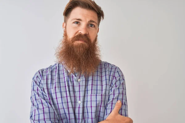 Redhead irish man listening to music using wireless earphones over isolated white background happy face smiling with crossed arms looking at the camera. Positive person.