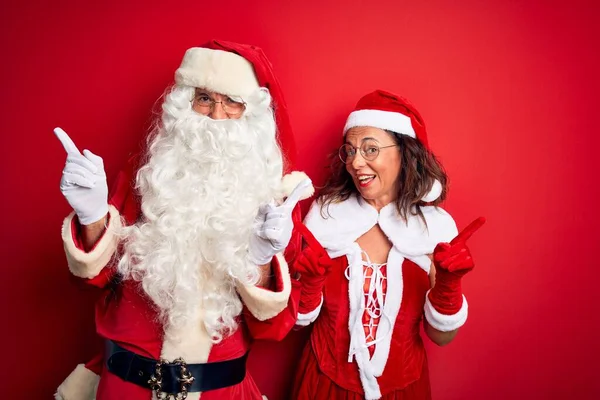 Paar Mittleren Alters Weihnachtsmannkostüm Und Brille Über Isoliertem Rotem Hintergrund — Stockfoto