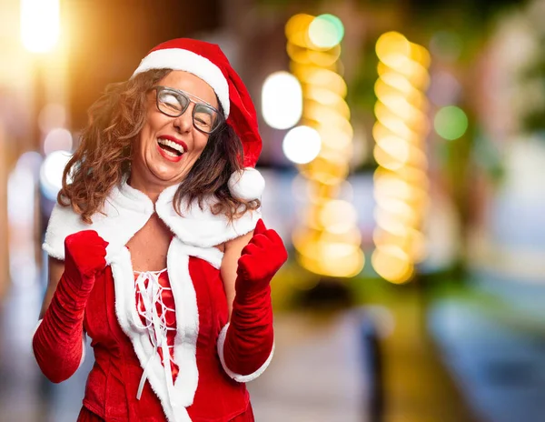 中年妇女穿着圣诞老人的服装 高兴而兴奋地举手投足 微笑着 尖叫着要成功 庆祝概念 — 图库照片