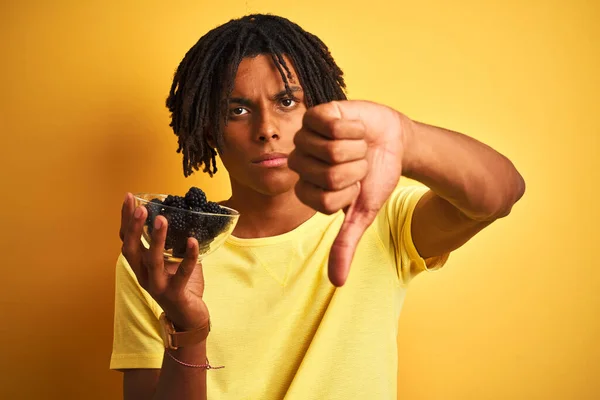 Afro Američan Dredy Drží Ostružiny Nad Izolovaným Žlutým Pozadím Rozzlobeným — Stock fotografie