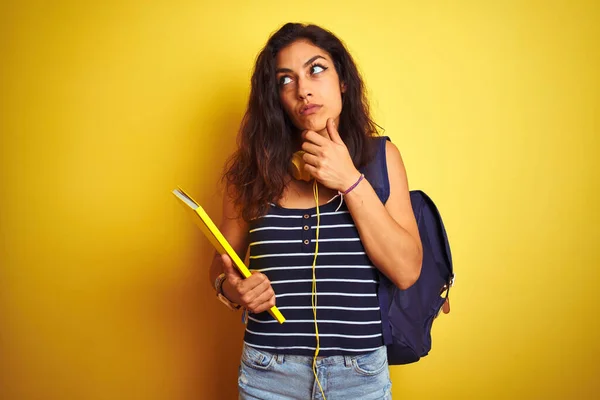 Studentin Mit Bakcpack Notizbuch Kopfhörer Über Isoliertem Gelbem Hintergrund Ernstes — Stockfoto