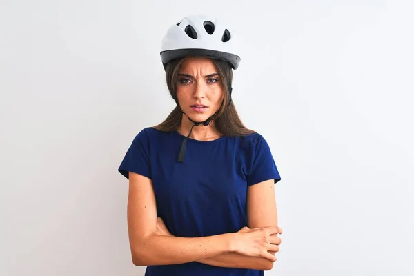 年轻美丽的骑自行车的女人 戴着安全的自行车头盔 在孤独的白色背景下 持怀疑和紧张的态度 满脸不赞成的表情与交叉的胳膊 消极的人 — 图库照片