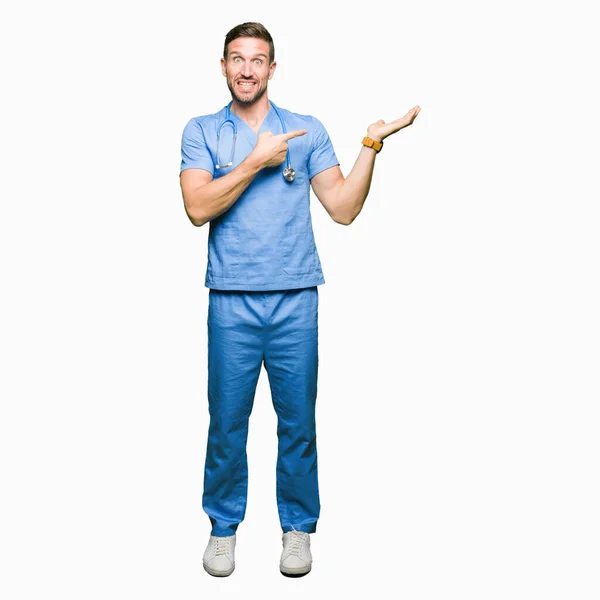 Guapo Doctor Hombre Vistiendo Uniforme Médico Sobre Fondo Aislado Sorprendido —  Fotos de Stock