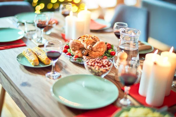 お祝いの休日にクリスマステーブルの設定 木の照明や装飾の周りに七面鳥とおいしい食事と伝統的な食品のフル — ストック写真