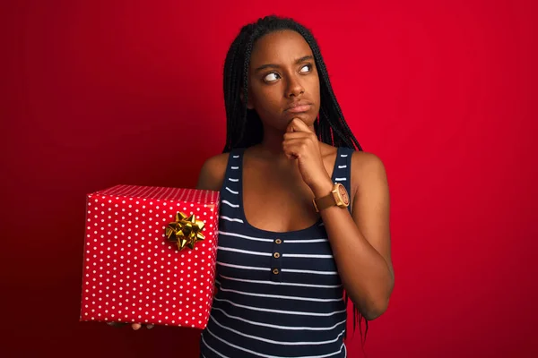 Mujer Afroamericana Joven Sosteniendo Regalo Cumpleaños Pie Sobre Fondo Rojo — Foto de Stock