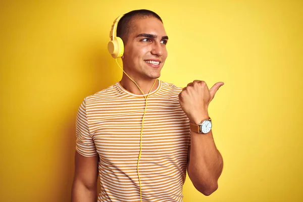 Молодий Красивий Чоловік Використовує Навушники Над Жовтим Ізольованим Тлом Посміхаючись — стокове фото