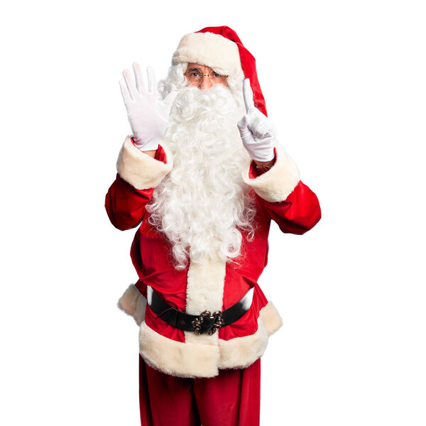 Middle age handsome man wearing Santa Claus costume and beard standing showing and pointing up with fingers number six while smiling confident and happy.