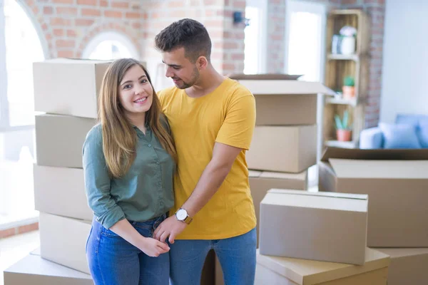 Junges schönes verliebtes Paar um Pappkartons zieht um — Stockfoto