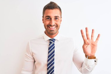 Genç yakışıklı, zarif iş adamı izole edilmiş arka planda dört numarayı gösterip işaret ederken kendinden emin ve mutlu bir şekilde gülümsüyor..