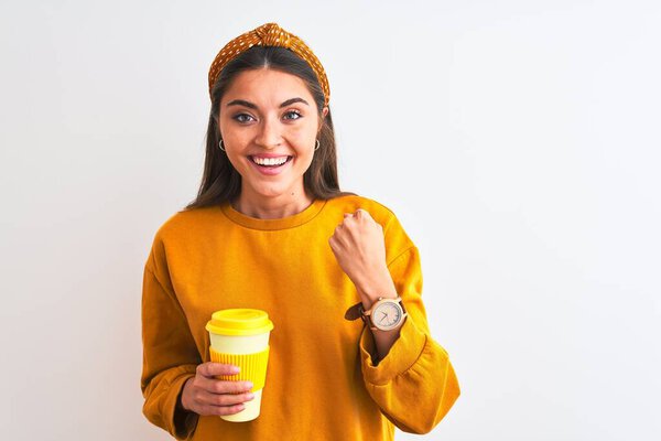 Young beautiful woman drinking glass of take away coffee over isolated white background screaming proud and celebrating victory and success very excited, cheering emotion