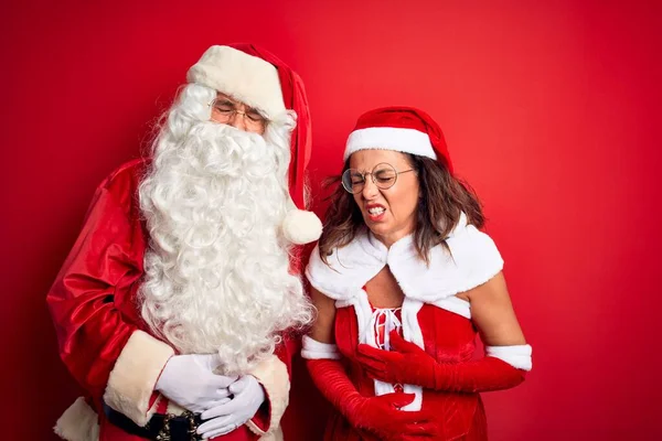 Paar Mittleren Alters Weihnachtsmannkostüm Und Brille Über Isoliertem Rotem Hintergrund — Stockfoto