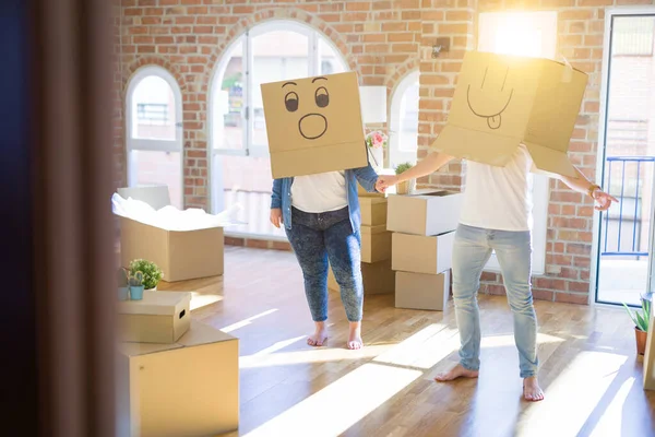 Komik emoji ile karton kutular giyen çılgın çift kafa üzerinde yüzler, yeni evde eğlenmek