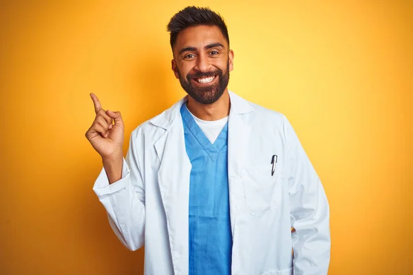 Junger Indischer Arzt Der Vor Isoliertem Gelben Hintergrund Mit Einem — Stockfoto