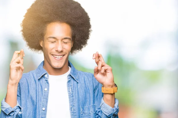 Joven Afroamericano Con Pelo Afro Sonriendo Cruzando Los Dedos Con —  Fotos de Stock