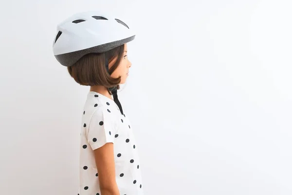 漂亮的小女孩戴着安全的自行车头盔 站在孤独的白色背景上观望 带着自信的微笑放松自己的姿态 — 图库照片
