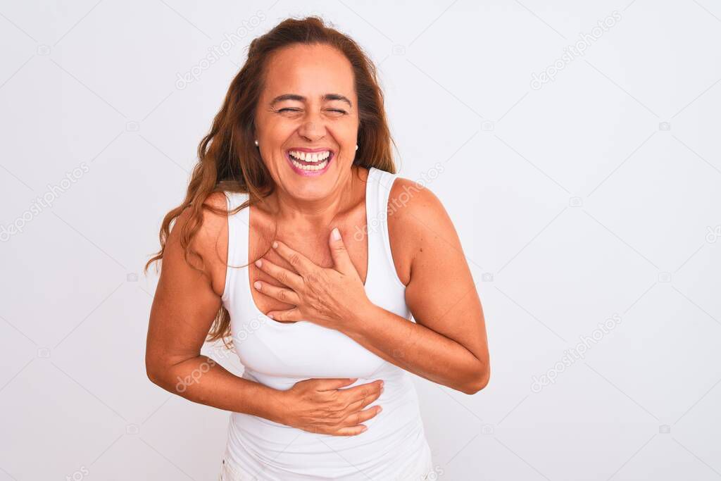 Middle age mature woman standing over white isolated background smiling and laughing hard out loud because funny crazy joke with hands on body.