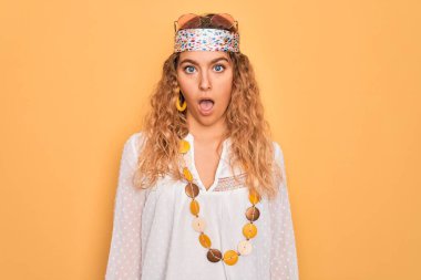 Genç, sarışın, mavi gözlü, güneş gözlüklü, aksesuar takan, kuşkucu ve alaycı bakışlı, ağzı açık, şaşırmış genç bir hippi kadın.