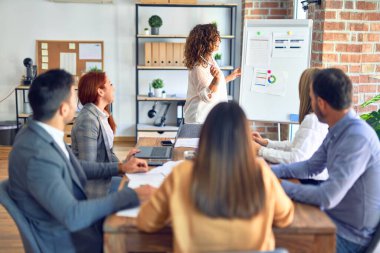 Group of business workers working together in a meeting. One of them making presentation to colleagues at the office