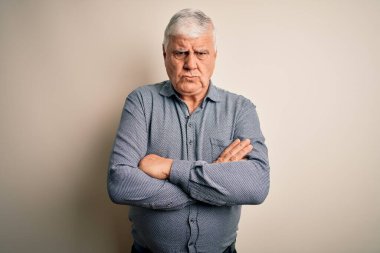 Üst düzey yakışıklı beyaz gömlekli adam izole edilmiş beyaz arka plan şüphecisi ve gergin kolları çaprazlanmış yüz ifadesini tasvip etmiyor. Negatif kişi.