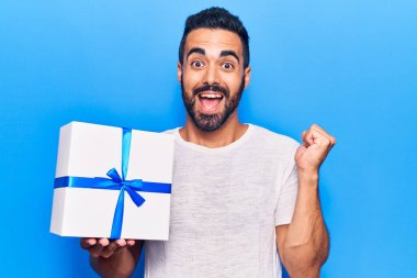 Genç İspanyol adam elinde bir hediye tutuyor. Gururla bağırıyor, zaferi kutluyor ve başarıyı kollarını kaldırarak kutluyor. 