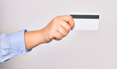 İzole edilmiş beyaz arka planda kredi kartı tutan beyaz bir kadının eli.