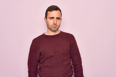 Mavi gözlü, sıradan bir süveter giyen genç, uykulu ve yorgun görünen, yorgunluktan bitkin düşmüş, akşamdan kalma, tembel gözlü bir adam..