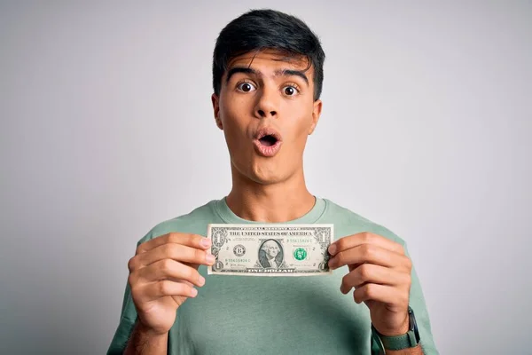 Młody Przystojny Mężczyzna Trzymający Banknoty Dolarowe Odizolowanym Białym Tle Przerażony — Zdjęcie stockowe