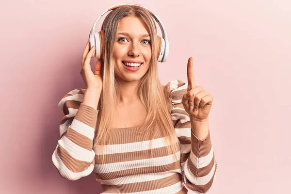 Young Blonde Woman Listening Music Using Headphones Smiling Happy Pointing — Stock Photo, Image