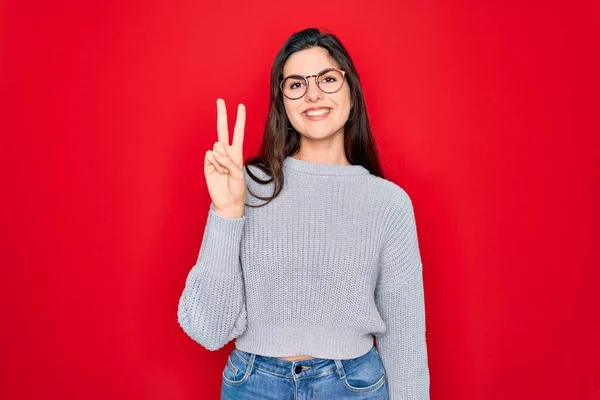 Joven Hermosa Morena Vistiendo Suéter Casual Sobre Fondo Rojo Mostrando —  Fotos de Stock