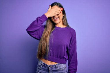 Mor izole edilmiş arka planda gözlük takan güzel ve zeki bir kadın. Gülümsüyor ve yüzünde şaşkınlıktan gözleri kapayarak gülüyor. Kör kavram.