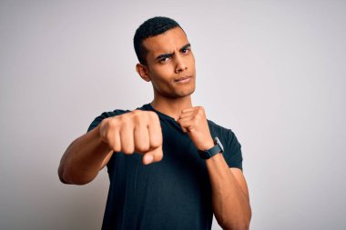 Genç, yakışıklı, Afro-Amerikalı bir adam. Sıradan tişörtler giyiyor. Beyaz arka plan üzerinde duruyor. Yumruk yumruğa dövüşüyor, agresif ve öfkeli bir saldırı.