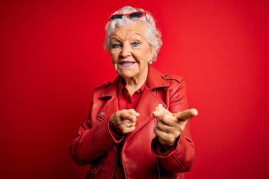 Son sınıf güzeli, gri saçlı, sıradan kırmızı ceket giyen ve güneş gözlüğü takan mutlu ve komik yüzlü bir kadın. İyi enerji ve titreşimler.