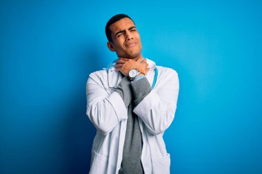 Palto giyen yakışıklı Afrikalı Amerikalı doktor ve mavi arka planda steteskop var. Boğulmak acı verici diye bağırıyor. Sağlık problemi. Boğulma ve intihar konsepti.