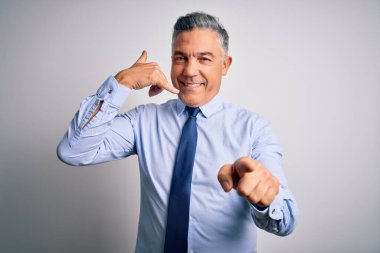 Orta yaşlı, yakışıklı, gri saçlı, şık gömlekli ve kravatlı bir iş adamı telefonda konuşarak seni işaret ediyor. Ara beni..