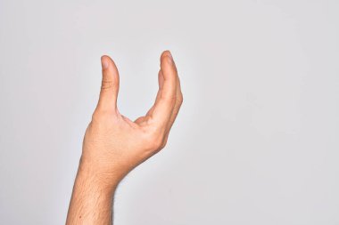 İzole edilmiş beyaz arka plan üzerinde parmaklarını gösteren beyaz bir adamın eli. Görünmez bir şeyi alıp, parmaklarıyla uzayı gösteren bir nesneyi tutuyor.