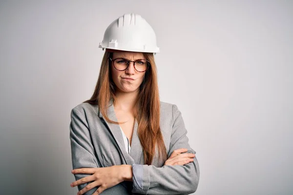 Jonge Mooie Roodharige Architect Vrouw Draagt Veiligheidshelm Witte Achtergrond Sceptisch — Stockfoto