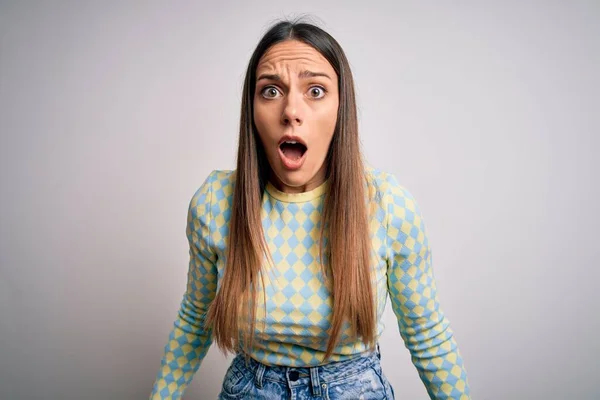 Young beautiful blonde woman with blue eyes standing over isolated background afraid and shocked with surprise expression, fear and excited face.