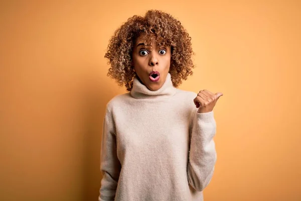 Fiatal Gyönyörű Afro Amerikai Visel Garbó Pulóver Sárga Háttér Meglepett — Stock Fotó