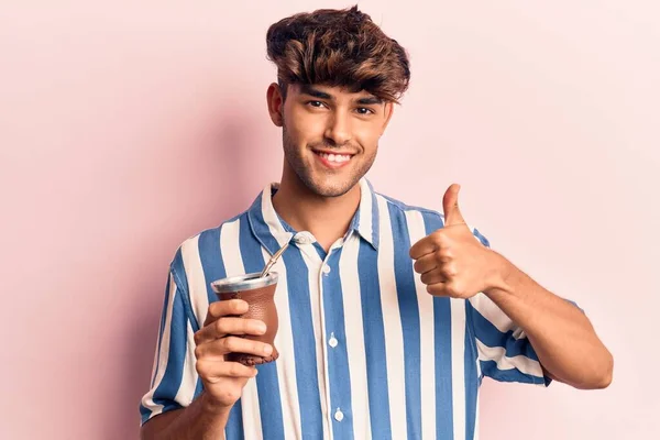 Joven Hispano Bebiendo Mate Infusión Sonriendo Feliz Positivo Pulgar Hacia —  Fotos de Stock