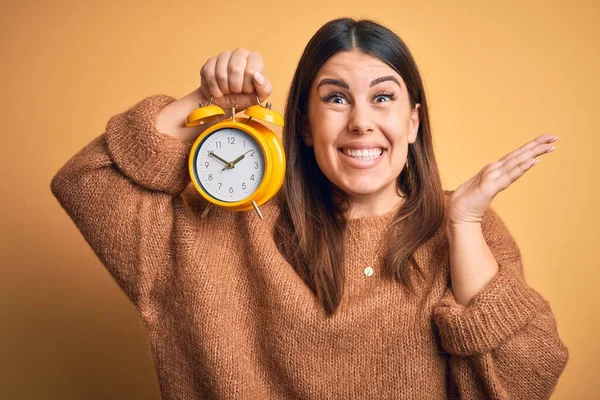 Jovem Mulher Bonita Segurando Despertador Sobre Fundo Laranja Isolado Muito — Fotografia de Stock