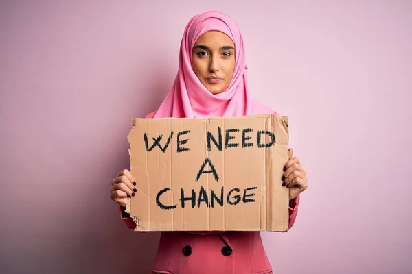 ピンクのイスラム教徒のヒジャーブを身に着けている活動家の女性バナーを保持します — ストック写真
