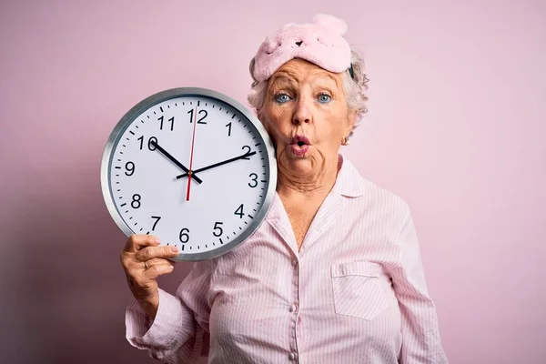 Senior Schöne Frau Trägt Schlafmaske Hält Große Uhr Über Isolierten — Stockfoto