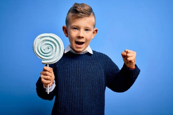 Młody Biały Dzieciak Jedzący Słodkiego Cukierka Lizaka Niebieskim Odizolowanym Tle — Zdjęcie stockowe