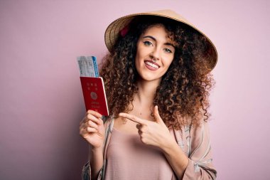 Kıvırcık saçlı, piercingli, Asya şapkalı, elinde Japon pasaportu olan güzel bir turist.