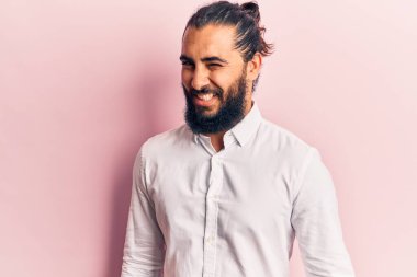 Gündelik giysiler giymiş genç bir Arap, kameraya seksi bir ifadeyle bakıyor, neşeli ve mutlu bir yüzle.. 