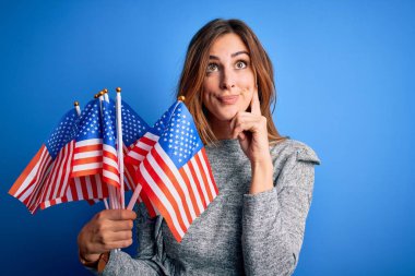 Amerika Birleşik Devletleri bayraklarını tutan genç, güzel, vatansever bir kadın beceriksizlik gününü kutluyor. Ciddi bir yüz ifadesi var.