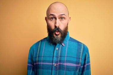 Sarışın, sakallı, sıradan tişörtlü yakışıklı. Sarı arka planda dikiliyor. Şaşırmış ve korkmuş bir ifade, korku ve heyecanlı bir yüz..