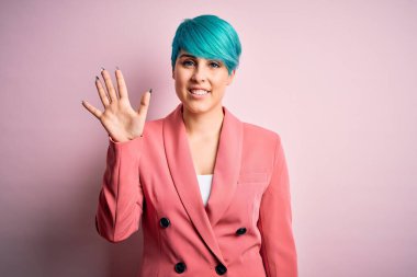 Mavi saçlı, pembe arka planda ceket giyen genç ve güzel bir iş kadını beş numaralı parmaklarıyla gülümseyerek kendinden emin ve mutlu bir şekilde onu işaret ediyor..